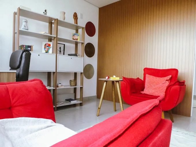 Sala de atendimento, com duas poltronas dispostas frente a frente e estante ao fundo